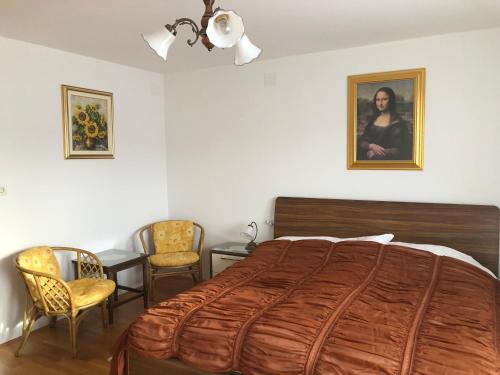 a bedroom with a large bed and two chairs at Sobe apartma Milena in Bled