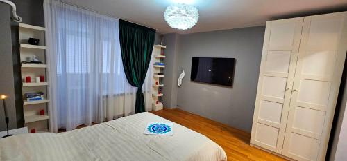 a bedroom with a white bed and a chandelier at Apartament Victoriei - Centru in Bucharest