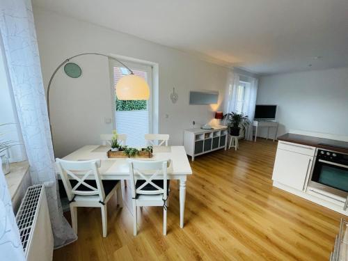 a kitchen and dining room with a white table and chairs at OstseeLiebe Garten, Terrasse und Strandnähe in Wendtorf