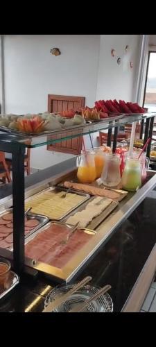 a kitchen with a counter top with a bunch of food at Hoteis Cattoni in Lages