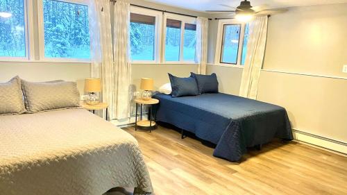 a bedroom with two beds and two windows at Alaska Getaway in Palmer