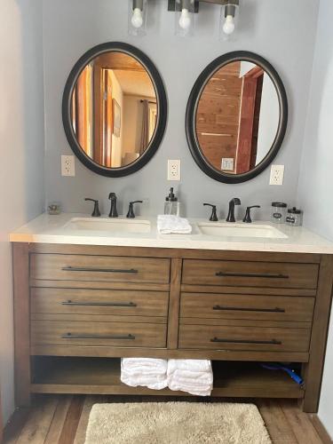 a bathroom with two sinks and two mirrors at Alaska Getaway in Palmer