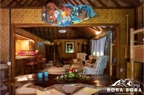 a living room with a table and a mirror at Villa Bora Bora - on Matira in Bora Bora