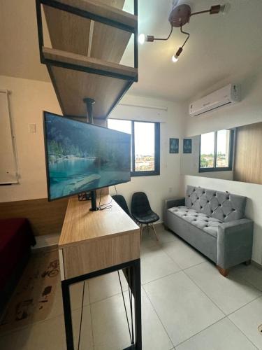 a living room with a television and a couch at APTO TESLA Novo,com Piscina e Ar condicionado in São Carlos