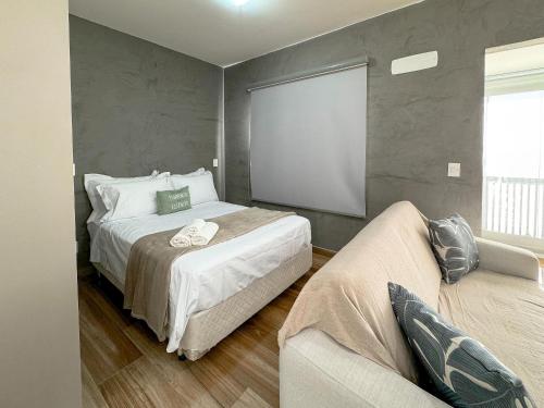 a bedroom with a large bed and a couch at Condomínio Residencial Unique Residence - São José do Rio Preto in Sao Jose do Rio Preto