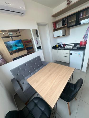 a kitchen and dining room with a wooden table and chairs at APTO TESLA Novo,com Piscina e Ar condicionado in São Carlos