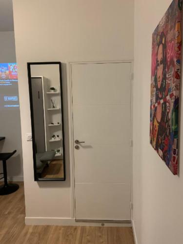 une porte blanche avec un miroir à côté d'un mur dans l'établissement La Suite Dream - GURVAND - Confort - Centre Ville, à Rennes