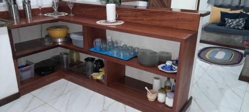 ein Holzregal mit Flaschen und anderen Gegenständen darauf in der Unterkunft Casa de Praia na Roça in Angra dos Reis