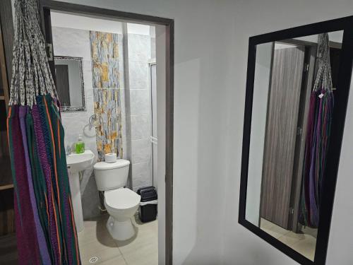 a bathroom with a toilet and a sink and a mirror at Apartaestudios Galanni in Valledupar