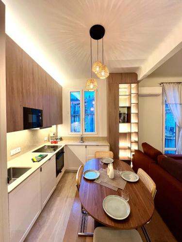 Il comprend un salon avec une table en bois et une cuisine. dans l'établissement Au port de Nice Sublime 2 pieces rénové a neuf climatisé, à Nice