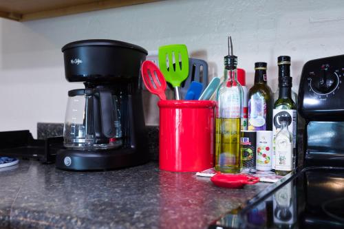 a counter with a coffee maker and a cup with utensils at Cozy House Pool Spa Tennis & Pickleball Courts in Tempe