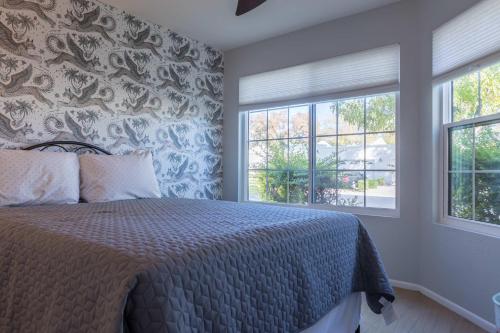 a bedroom with a bed and two windows at Cozy House Pool Spa Tennis & Pickleball Courts in Tempe