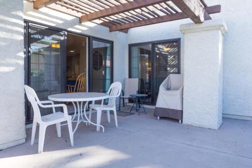 a patio with a table and chairs and windows at Cozy House Pool Spa Tennis & Pickleball Courts in Tempe