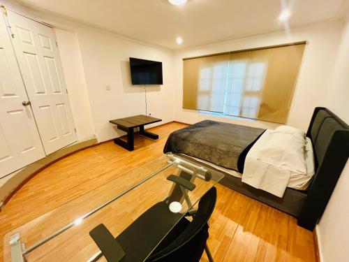 a bedroom with a bed and a table and a tv at Venator House Habitación sencilla #13 in Miravalle