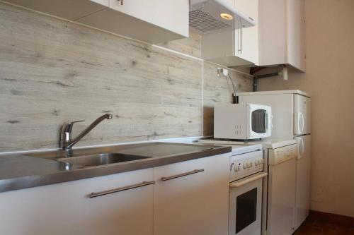 une petite cuisine avec un évier et un micro-ondes dans l'établissement Appartement 2 pièces PORT LA NOUVELLE PN210-036, à Port-la-Nouvelle