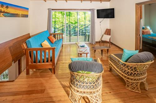 a living room with a blue couch and chairs at 2 Coco Locos at Sunset in Seine Bight Village
