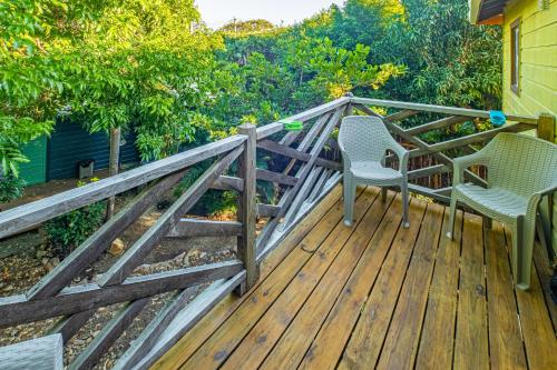two chairs on a wooden deck with a fence at 2 Coco Locos at Sunset in Seine Bight Village