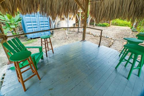 a patio with chairs and tables and a thatched roof at 2 Coco Locos at Sunset in Seine Bight Village