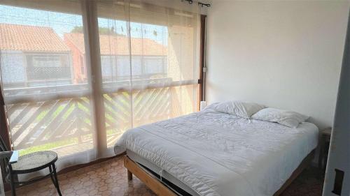 une chambre avec un lit et une grande fenêtre dans l'établissement APPARTEMENT 3 pieces PORT LA NOUVELLE PN340-126, à Port-la-Nouvelle