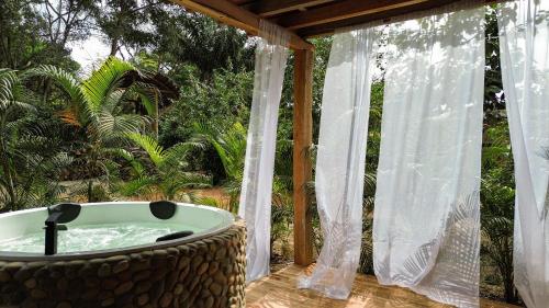 a bath tub on a deck with a pergola at Casa Peregrina in Ayampe
