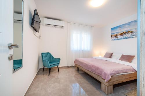 a bedroom with a bed and a blue chair at Apartment ILUX-3 in Novigrad Dalmatia