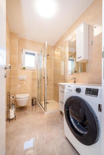 a washing machine in a bathroom with a shower at Apartment ILUX-3 in Novigrad Dalmatia