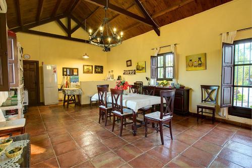 a kitchen and dining room with a table and chairs at Reservaloen Hacienda las Marciagas in Benacazón