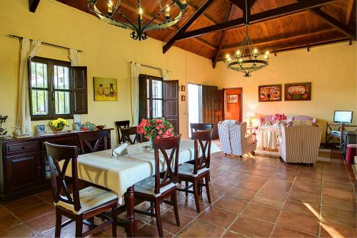 uma sala de jantar com uma mesa e cadeiras num quarto em Reservaloen Hacienda las Marciagas em Benacazón