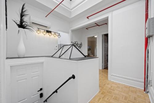a white kitchen with a counter and a hallway at Vintage Luxe NY - Designer Lofts & Apartments NYC in New York