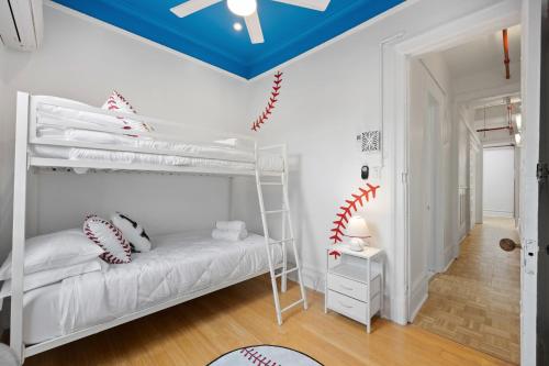 a bedroom with a white bunk bed with baseball pillows at Vintage Luxe NY - Designer Lofts & Apartments NYC in New York