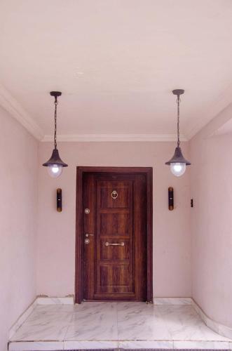 a room with a wooden door and two lights at Lovely 3 bedroom Villa in Ikorodu