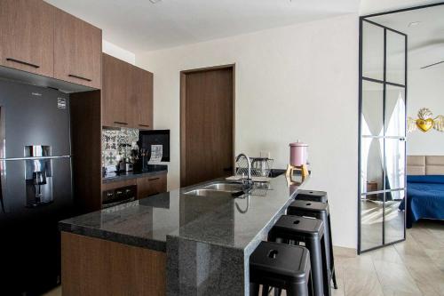 a kitchen with a counter and some black stools at Modern loft with luxury amenities in San Miguel in San Miguel de Allende