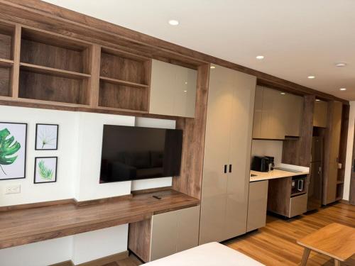 una cucina con armadi in legno e una TV a schermo piatto di Suite de Lujo en Vou 106 a Bogotá