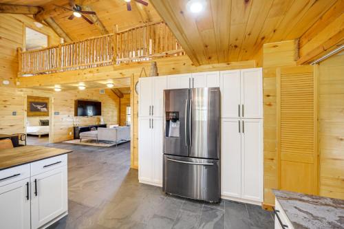 a kitchen with a stainless steel refrigerator in a cabin at 5 Mi to Dtwn Dripping Springs Cabin with Jacuzzi! in Dripping Springs