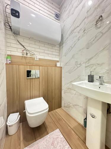 a bathroom with a white toilet and a sink at 3 bedroom apartment Elizaveta in Bishkek