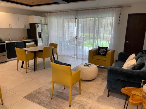 a living room with a couch and a table and chairs at Villa Paraiso do Mar in Jacó