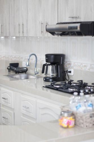 a kitchen with a stove with a coffee pot on it at Apartamento Genesis in Quimbaya