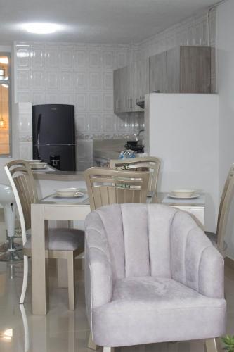 a kitchen with a table and chairs and a couch at Apartamento Genesis in Quimbaya