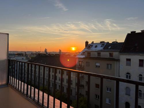 a view of the sunset from the balcony of a building at Buda Top Floor Apartment with Terrace & View in Budapest