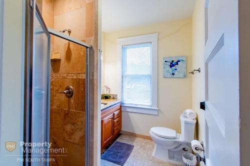 a bathroom with a shower and a toilet and a sink at Can't Buy Me Love - U of Tampa Flat in N Hyde Park in Tampa