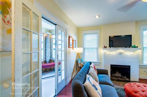 a living room with a blue couch and a fireplace at Can't Buy Me Love - U of Tampa Flat in N Hyde Park in Tampa