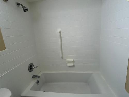 a white bath tub in a bathroom with a toilet at Live In Lodge Gainesville in Gainesville