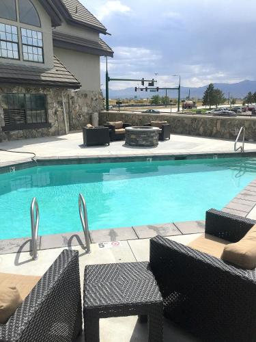 a large swimming pool with chairs and a house at Radisson Hotel Salt Lake City Airport in Salt Lake City