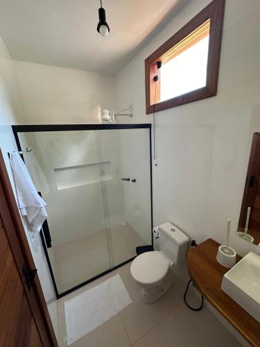 a bathroom with a glass shower and a toilet at Casa Jubarte in Alcobaça