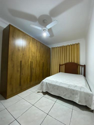 a bedroom with a bed and a wooden cabinet at Apartamento inteiro 02 quartos, no térreo - hospeda confortavelmente até 6 pessoas - Ipatinga -MG in Ipatinga
