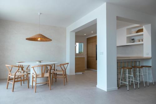 Una cocina y un comedor con mesa y sillas. en Villa Hondartza Corralejo, en Corralejo