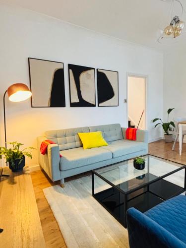 a living room with a couch and a glass table at Cosy & Modern in London