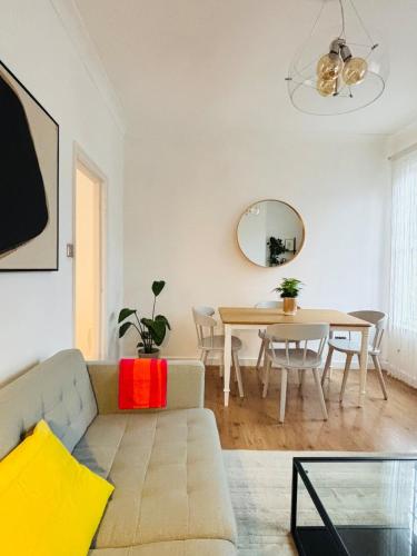 a living room with a couch and a table at Cosy & Modern in London