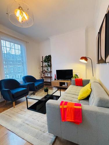 a living room with a couch and a tv at Cosy & Modern in London