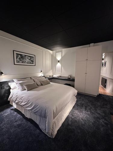 - une chambre avec un grand lit blanc et des armoires blanches dans l'établissement Suite Junior, à Saint-Brieuc